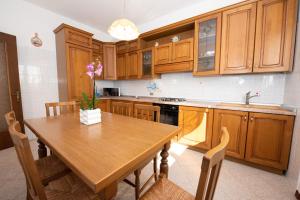 a kitchen with wooden cabinets and a wooden table at Villa Margherita in Torri del Benaco