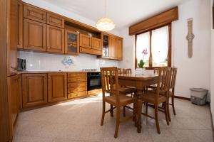 a kitchen with wooden cabinets and a table and chairs at Villa Margherita in Torri del Benaco +19 photos