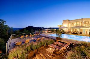a resort with a pool and chairs and a building at Hotel Kronelamm im Schwarzwald in Bad Teinach-Zavelstein