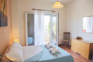 a bedroom with a bed and a dresser and a window at J&B Countryside Life in Ágios Matthaíos
