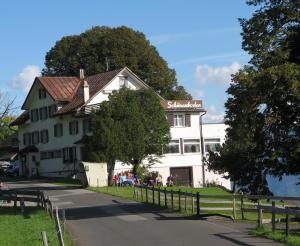 a white building with a wooden fence in front of it at Zimmer & z'Morgä Schönenboden in Wildhaus