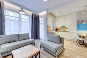 a living room with a couch and a chair and a table at Apartamenty Gdansk EU - Neptun Park in Gdańsk