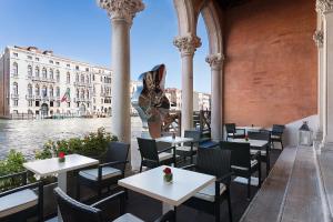 a restaurant with tables and chairs next to the water at Sina Centurion Palace in Venice