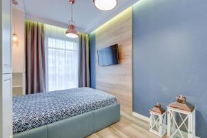 a bedroom with a bed and a tv on a wall at Apartamenty Gdansk EU - Neptun Park in Gdańsk