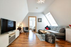 ein Wohnzimmer mit einem Sofa und einem TV in der Unterkunft Altstadt Apartment Deluxe in Cottbus