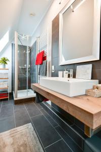 ein Badezimmer mit einem weißen Waschbecken und einem Spiegel in der Unterkunft Altstadt Apartment Deluxe in Cottbus