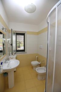 a bathroom with two toilets and a sink and a shower at Residence San Salvatore in Palinuro