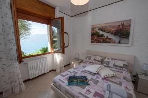 a bedroom with a bed and a large window at Villa Margherita in Torri del Benaco