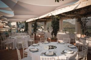 a wedding reception in a room with white tables and chairs at Hotel Bonadies in Ravello
