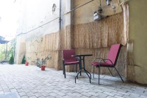 dos sillas y una mesa junto a una pared en Raphaela Residence, en Bistriţa