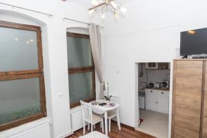kuchnia i jadalnia ze stołem i telewizorem w obiekcie Raphaela Residence w Bystrzycy