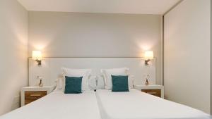 Un dormitorio con una gran cama blanca con almohadas verdes. en Las Nasas by Labranda, en Playa del Inglés 49 fotos más