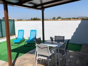 une terrasse avec une table et des chaises ainsi qu'une grande étendue d'eau dans l'établissement Suites D'Elice, à El Palmar