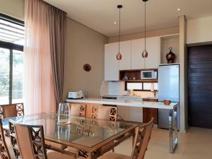 een keuken met een glazen tafel en een koelkast bij Zimbali Suites 611 in Ballito