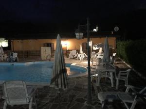 una piscina notturna con sedie e ombrelloni di Chalet San Massimo a San Massimo
