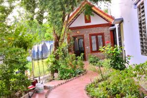 a small house with a garden in front of it at Tam Coc Family Friendly Homestay in Ninh Binh
