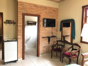 um quarto com duas cadeiras e uma parede de tijolos em Pouso Flor de Manacá em Tiradentes