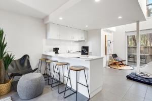 a kitchen with a counter and stools in a room at Tangles in Ballarat