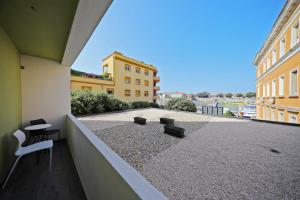 a balcony with chairs and tables and a view of a building at La Dolce Vita da Zara - Luxury Rooms in Zadar