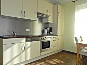 una cucina con armadietti bianchi ed elettrodomestici in acciaio inossidabile di Villa Ilona a Ahlbeck