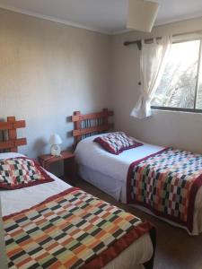 Habitación de hotel con 2 camas y ventana en Apart Hotel Gran Pacifico, en La Serena