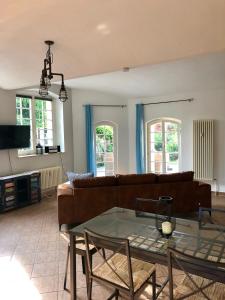 een woonkamer met een bank en een glazen tafel bij Ferienwohnung am Wasser Villa Graf von Pfeil in Dresden