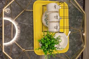 a plant in a yellow holder with a toilet at Chengdu Qingyang·Lihua Street· Locals Apartment 00116030 in Chengdu