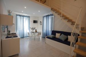 una cucina e un soggiorno con divano e scala di I Loft di Nonna Vincenza a Catania