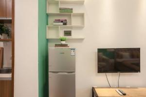 a kitchen with a refrigerator and a tv on a wall at Chengdu Qingyang·Lihua Street· Locals Apartment 00116030 in Chengdu