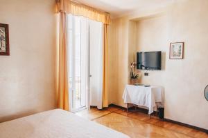 貝拉焦的住宿－蘇伊色酒店，一间卧室配有一张床、一张桌子和一个窗户。