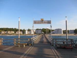 a pier with benches and a sign on the water at Exkl_ App_ Buhne_ Kamin_ W_LAN_ 25 in Börgerende-Rethwisch