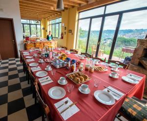 einem langen Tisch mit einem roten Tischtuch mit Nahrung darauf in der Unterkunft La Casa Rossa Country House in Piazza Armerina