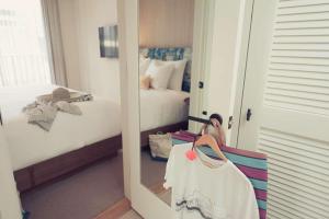 a mirror in a room with a bedroom with a bed at The Surfjack Hotel & Swim Club in Honolulu
