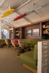 a waiting room with a green couch and chairs at The Surfjack Hotel & Swim Club in Honolulu