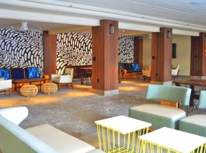 a lobby with tables and chairs and a zebra wall at The Surfjack Hotel & Swim Club in Honolulu