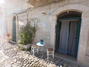 een tafel en twee stoelen voor een gebouw bij Gli Ipogei nel cuore di matera in Matera