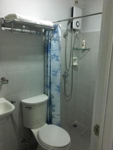 a bathroom with a toilet and a shower at Simply Comfy 916 (Cityscape Bacolod) in Bacolod