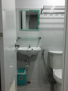 a bathroom with a sink and a toilet and a mirror at Simply Comfy 916 (Cityscape Bacolod) in Bacolod