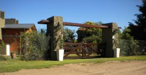 een houten bank voor een hek bij Las Casitas de Pepin in Santa Rosa de Calamuchita