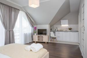 Habitación blanca con cama y cocina en Willa Przystań, en Jastarnia