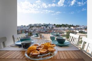 een tafel met een bord gebak op een balkon bij Casa Kiki in Ferragudo