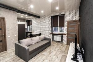 ein Wohnzimmer mit einem Sofa und einem TV in der Unterkunft Loft Apartment on Svobody in Kamjanske