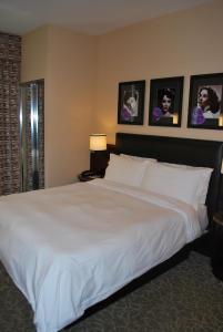 a large white bed in a bedroom with pictures on the wall at Washington Square Hotel in New York