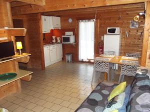 eine Küche und ein Wohnzimmer in einem Blockhaus in der Unterkunft La Roche du Moulin in Saint-Moré