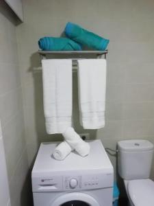 アリカンテにあるLukentum Suitesの小さなバスルーム(洗濯機、タオル付)