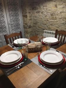 a wooden table with plates and napkins on it at Narcea Turismo Real in Cangas del Narcea