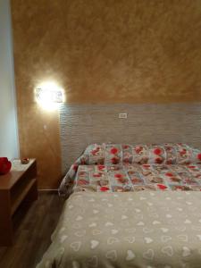 a bedroom with a bed with red roses on it at Mary BeB in Le Torri