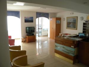een woonkamer met een bureau en een aantal stoelen bij Hotel Eliani in Grado