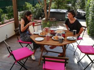 シントラにあるSintra/Colares Beach House with Mountain Viewの二人の女がテーブルに座って食べ物を食べている