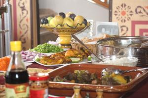 a table topped with lots of food and a bowl of fruit at Hôtel Sable d'Or in Tan-Tan